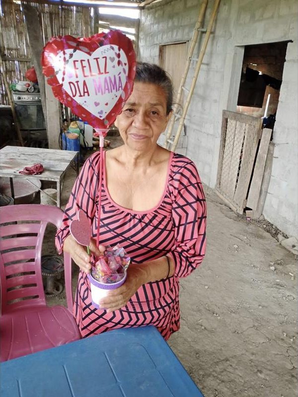 Una adulta mayor celebra el Día de la Madre con un globo