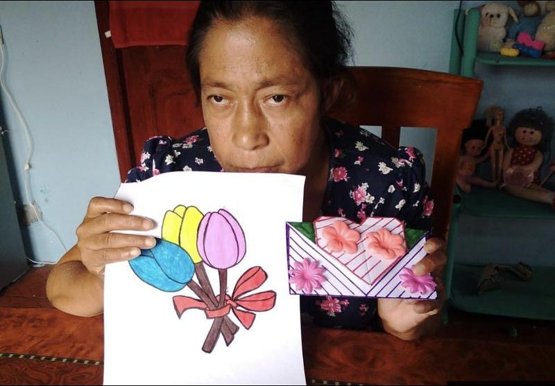 Una usuaria muestra el dibujo y la tarjeta que elaboró